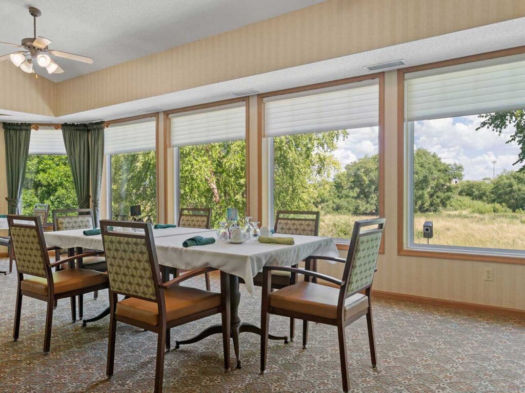 Dining room at Cornerstone Assisted Living in Plymouth, MN, with large windows and scenic views.