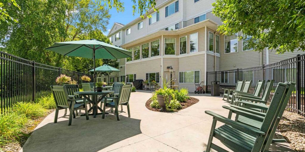 Cornerstone Assisted Living patio with green umbrellas and seating, similar to the setting for the upcoming Night to Unite celebration.