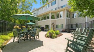 Cornerstone Assisted Living patio with green umbrellas and seating, similar to the setting for the upcoming Night to Unite celebration.