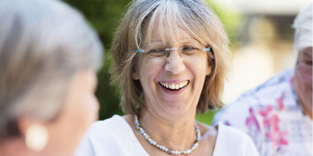 Senior woman smiling at another person