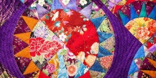 Colorful patchwork quilt with vibrant floral and geometric patterns, similar to those that will be showcased at Cornerstone Assisted Living.