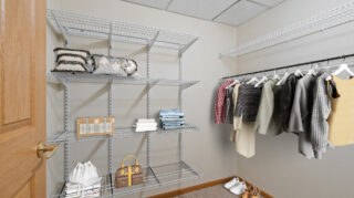 Walk-in closet with shelving and hanging space in a private apartment at Cornerstone Assisted Living in Plymouth MN.