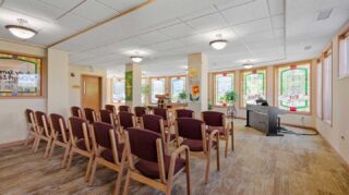 Chapel with seating, stained glass windows, and piano at Cornerstone Assisted Living in Plymouth MN.