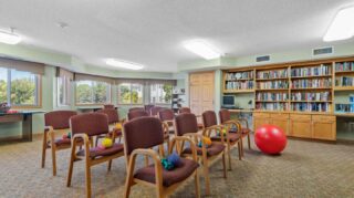 Fitness activity room with chairs, exercise equipment, and bookshelves at Cornerstone Assisted Living in Plymouth MN.