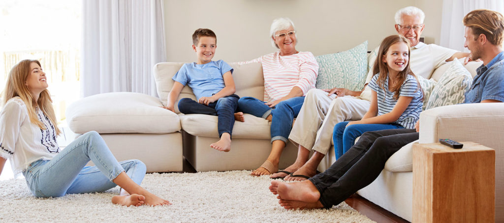 Residents sit together in a comfortable living room and spend time socializing at a community like Cornerstone Independent Living in Plymouth MN.