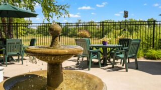 Outdoor patio with fountain, seating, and landscaped views at Cornerstone Assisted Living in Plymouth MN.